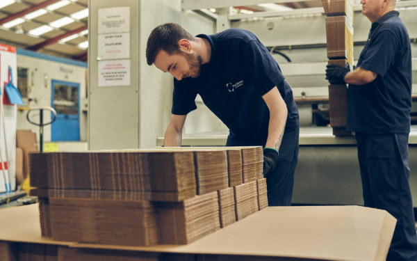 Male McLaren worker handling corrugated cardboard packaging